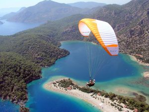 Ölüdeniz Yamaç Paraşütü Fiyat Ölüdeniz Yamaç Paraşütü Fiyatı Ölüdeniz, Muğla iline bağlı Fethiye ilçesine ait bir tatil beldesidir. Ölüdeniz, dünyaca ünlü bir plajı ve turkuaz renkli denizi ile bilinir. Ayrıca, Ölüdeniz'in çevresindeki Babadağ Dağ, yamaç paraşütü için popüler bir destinasyondur. Fethiye Ölüdeniz plajı manzarasını en iyi izlemenin en iyi yolu hiç şüphesiz Ölüdeniz yamaç paraşütü dür. Babadağ Dağı, Ölüdeniz'in hemen arkasında yükselen bir dağdır ve zirvesinden muazzam bir manzara sunar. Bu özellik, yamaç paraşütü tutkunları için eşsiz bir deneyim sunar. Babadağ'dan atlayan yamaç paraşütçüleri, Ölüdeniz'in eşsiz manzarası ve turkuaz renkli denizi eşliğinde serbestçe uçabilirler. Yamaç paraşütü, genellikle deneyimli eğitmenler eşliğinde gerçekleştirilir ve hayatınızın en unutulmaz anı Babadağ'ın zirvesinden başlar. Ölüdeniz'in ünlü Belcekız Plajı'na iniş yapmak, bu aktivitenin keyifli bir yönüdür. Eğer macera ve adrenalini seven birisiyseniz, Ölüdeniz'de yamaç paraşütü deneyimi yaşamanızı tavsiye ederiz. Ancak, bu tür aktiviteleri gerçekleştirmeden önce güvenilir yolu profesyonel pilotlar ile hizmete veren Butterfly Paragliding şirketini tercih etmenizdir. Ölüdeniz Yamaç Paraşütü yaz – kış hava şartlarına bağlı olarak yapılmaktadır. Paraşüt pistleri 1200-1700-1800-1970 metre de yer almaktadır. Ölüdeniz den hareket ile yaklaşık 30 dakika sonra uçuş yapılacak pistte ulaşır. Burada pilotların hazırlıkları sonrasında pilot ve yolcu pistten aşağıya doğru koşarak kalkış yapılmaktadır. Yamaç paraşütü yapmak için bayanlarda 80 kğ – erkeklerde ise 100 kğ üzerinde olmamanız gerekmektedir. Uçuş sonrası inişler Ölüdeniz plajına yapılmaktadır. Ölüdeniz Yamaç Paraşütü Fiyatı Ölüdeniz paraşüt fiyatı dönemsel olarak değişmektedir. Yamaç paraşütü fiyatlarına pist kullanım ücreti, siğorta, dağa çıkış ücreti dahildir. Gopro kamera foto video ve 360 derece panoramik fotoğraflar ise fiyata dahil değildir. Ölüdeniz Yamaç Paraşütü Fiyat 